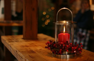 red lighted candle on brown wooden frame